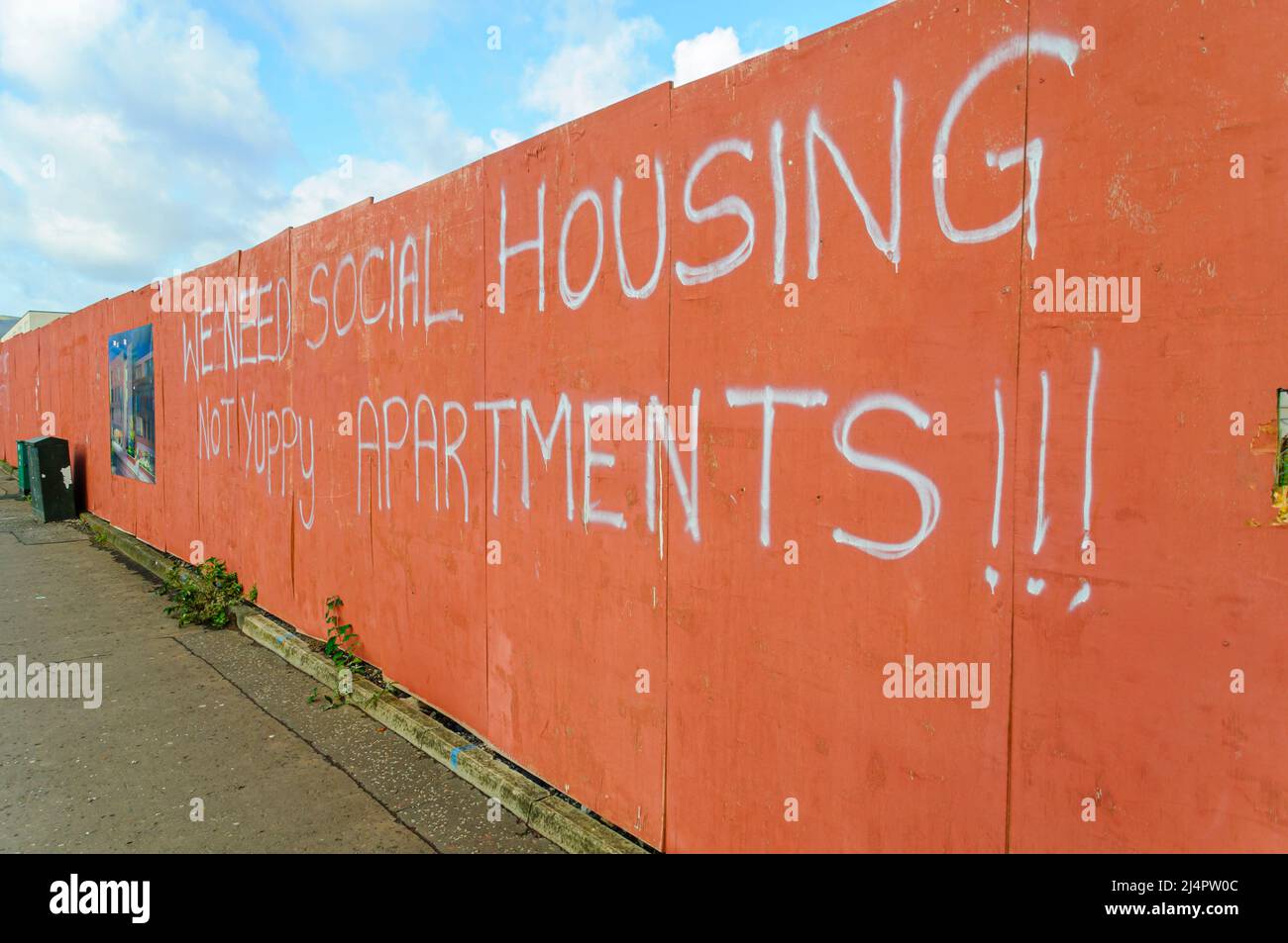Graffiti protesting the building of an apartment block saying 'We need social housing, not yuppy apartments', Belfast, Northern Ireland. Stock Photo