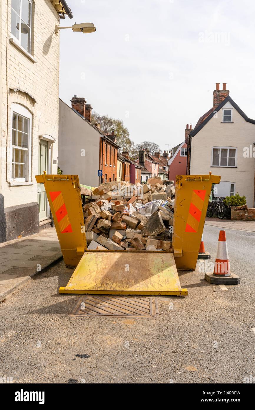 A builders skip containing rubble and bricks from a ongoing home
