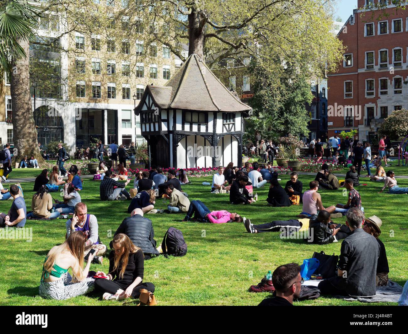 A view of people relaxing on a sunny Spring day in Soho Square Gardens in London UK Stock Photo