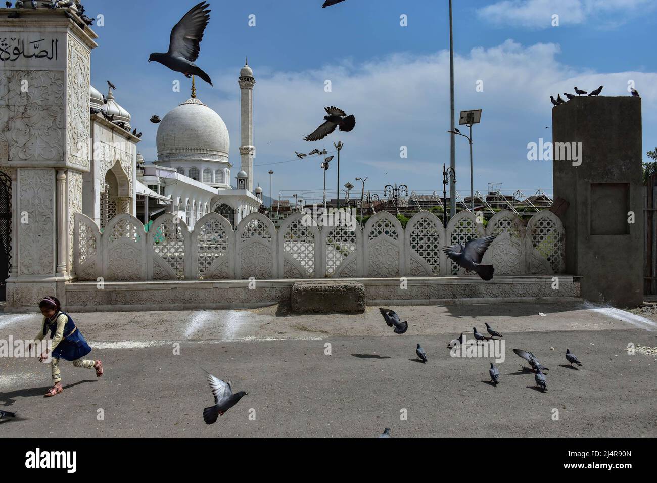 Srinagar, India. 17th Apr, 2022. A girl chases after pigeons outside the Hazratbal Shrine during the ongoing month of Ramadan. Muslims throughout the world are marking the month of Ramadan, the holiest month in the Islamic calendar in which devotees fast from dawn till dusk. (Photo by Saqib Majeed/SOPA Images/Sipa USA) Credit: Sipa USA/Alamy Live News Stock Photo