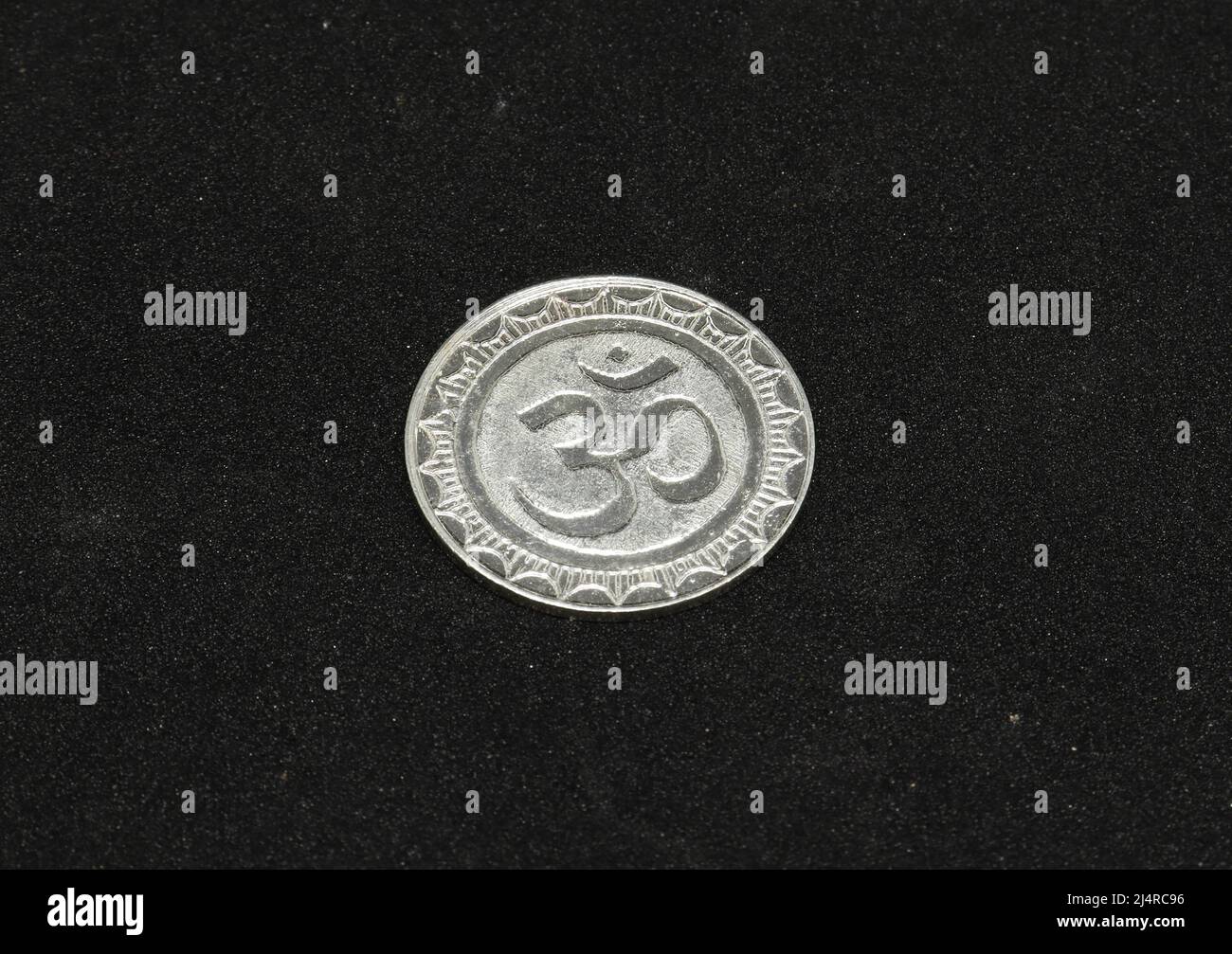 ohm symbol silver metal coin. on a black background Stock Photo