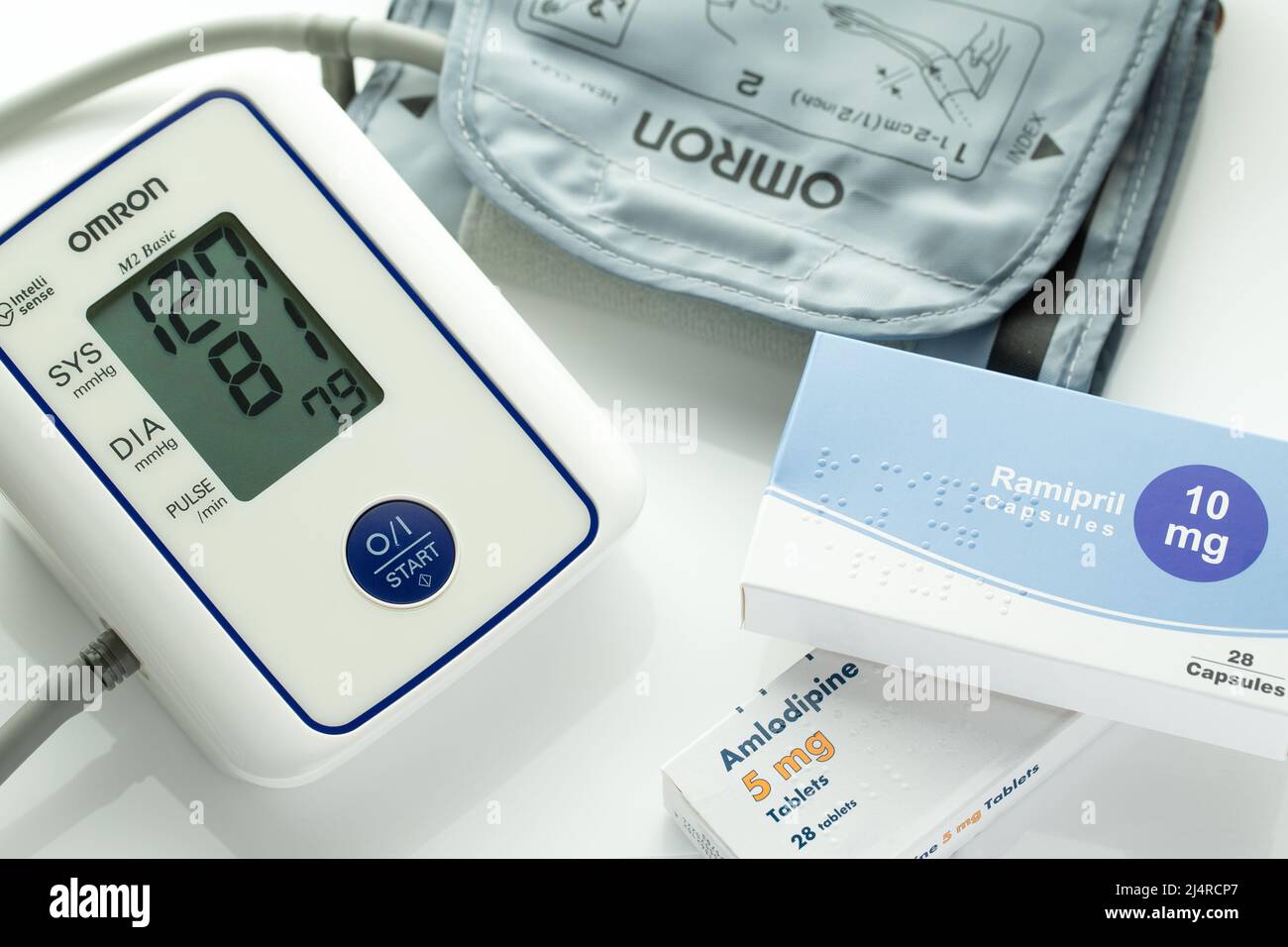 Blood Pressure monitor with cuff and  high blood pressure tablets. Ramipril and Amlodipine blood pressure tablets. White Background. Stock Photo