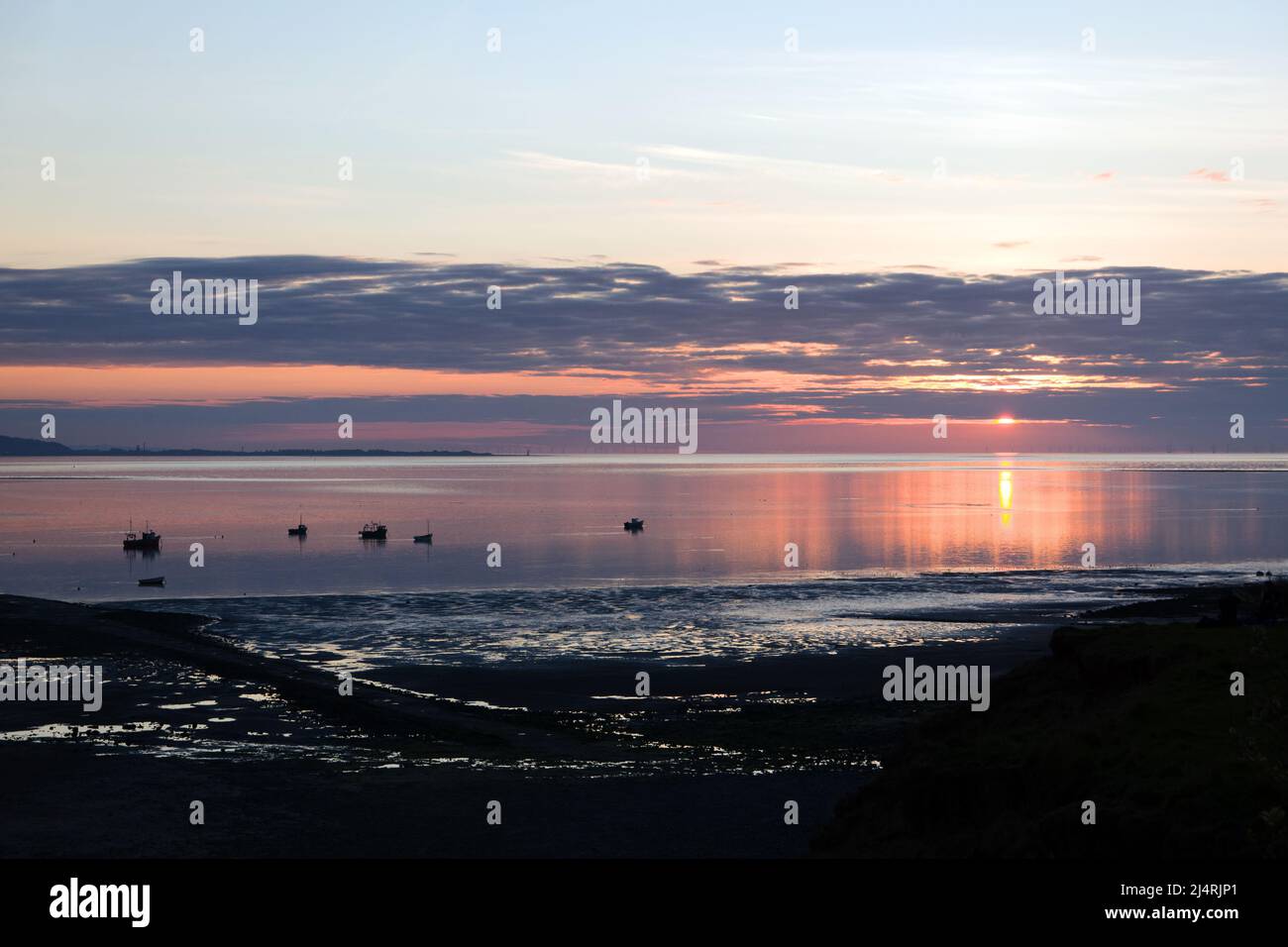 The Dee Estuary here seen at sunset forms a boundary between the Wirral Peninsula in north-west England and Flintshire in north-east Wales. Stock Photo