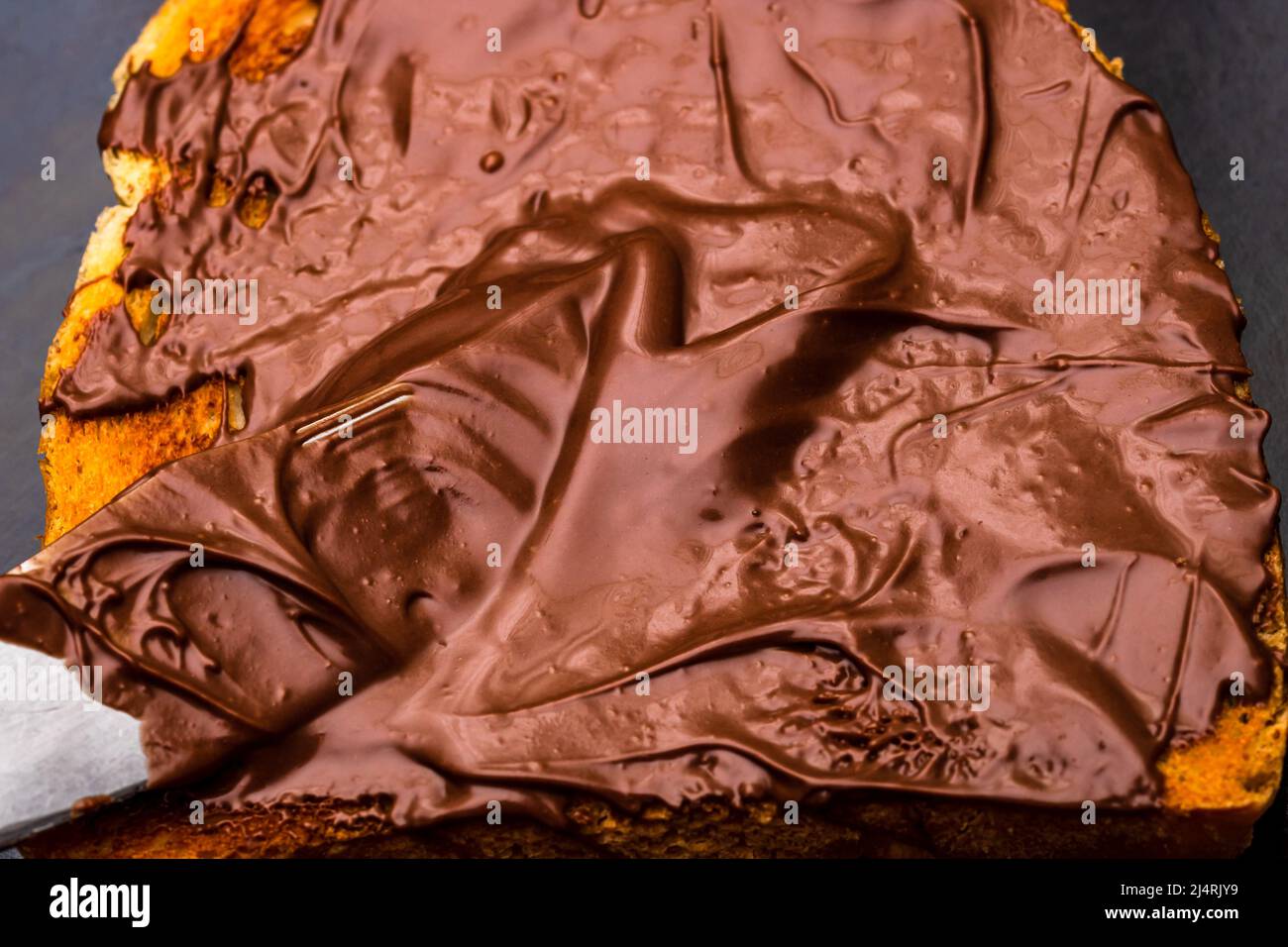 Spreading chocolate cream on toasted bread Stock Photo