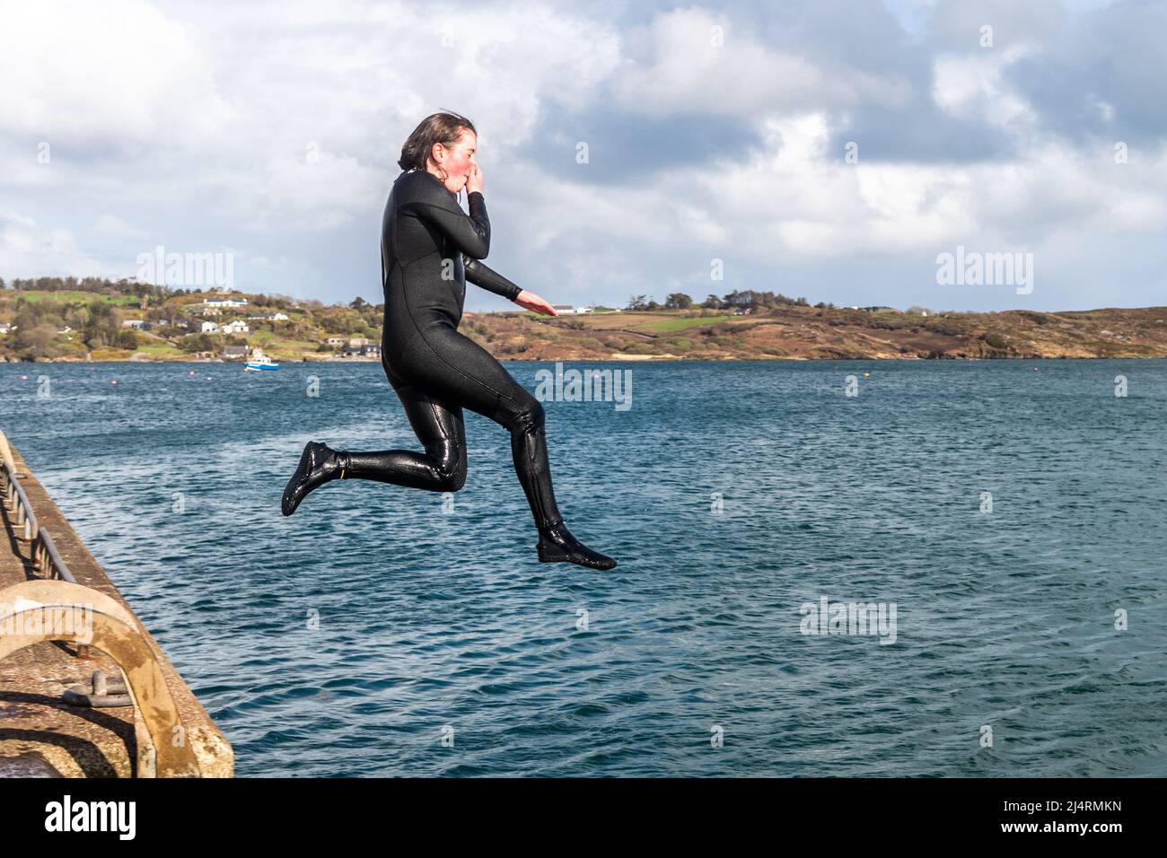 Schull, West Cork, Ireland. 17th Apr, 2022. On a sunny but breezy day in West Cork, Ella Britton from Cobh jumps off the pier in Schull. Credit: AG News/Alamy Live News Stock Photo