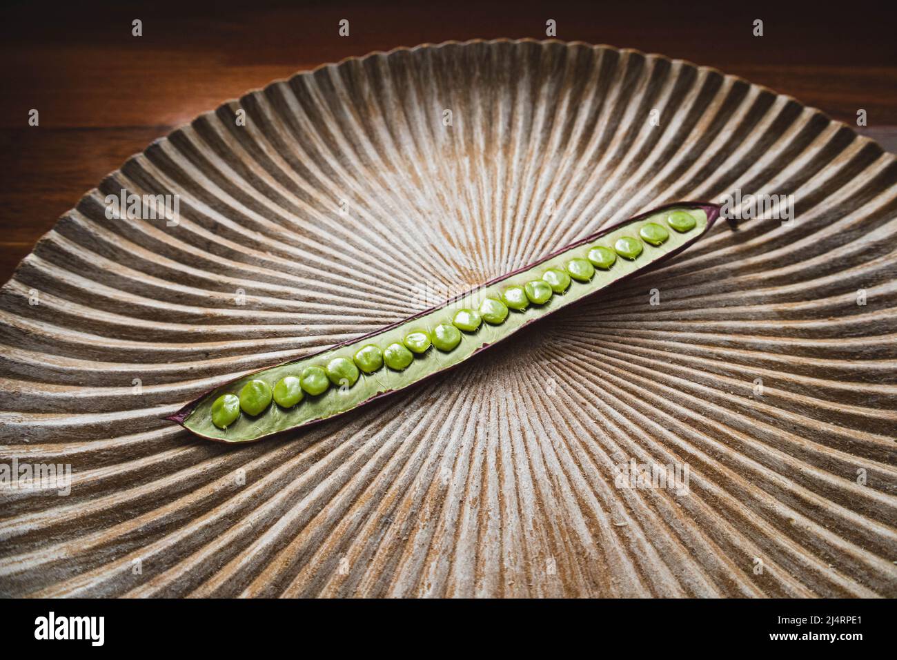 One Guaje seed pod on a plate in Oaxaca, Mexico. Stock Photo