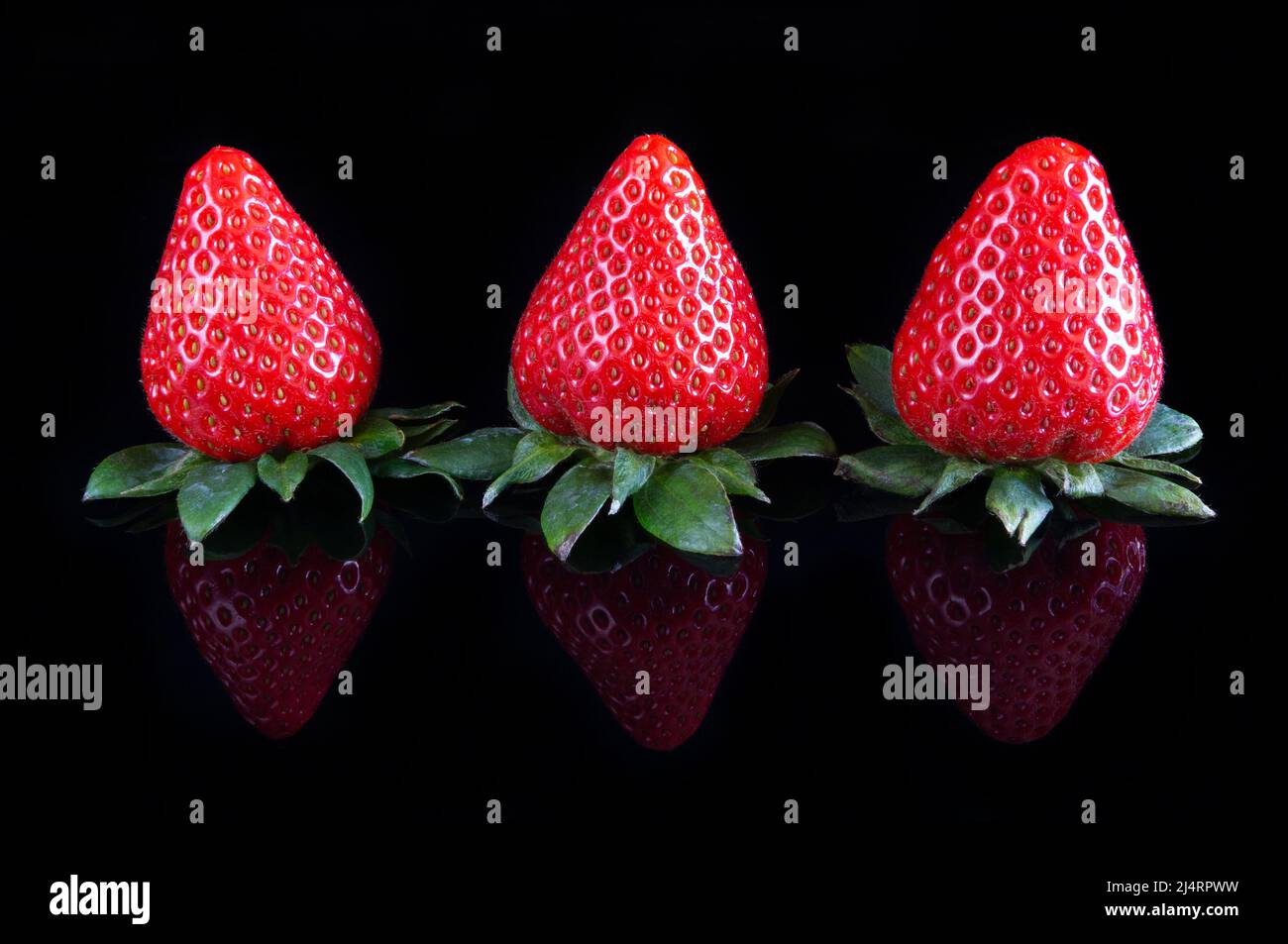 Fresh strawberries over reflective black background Stock Photo