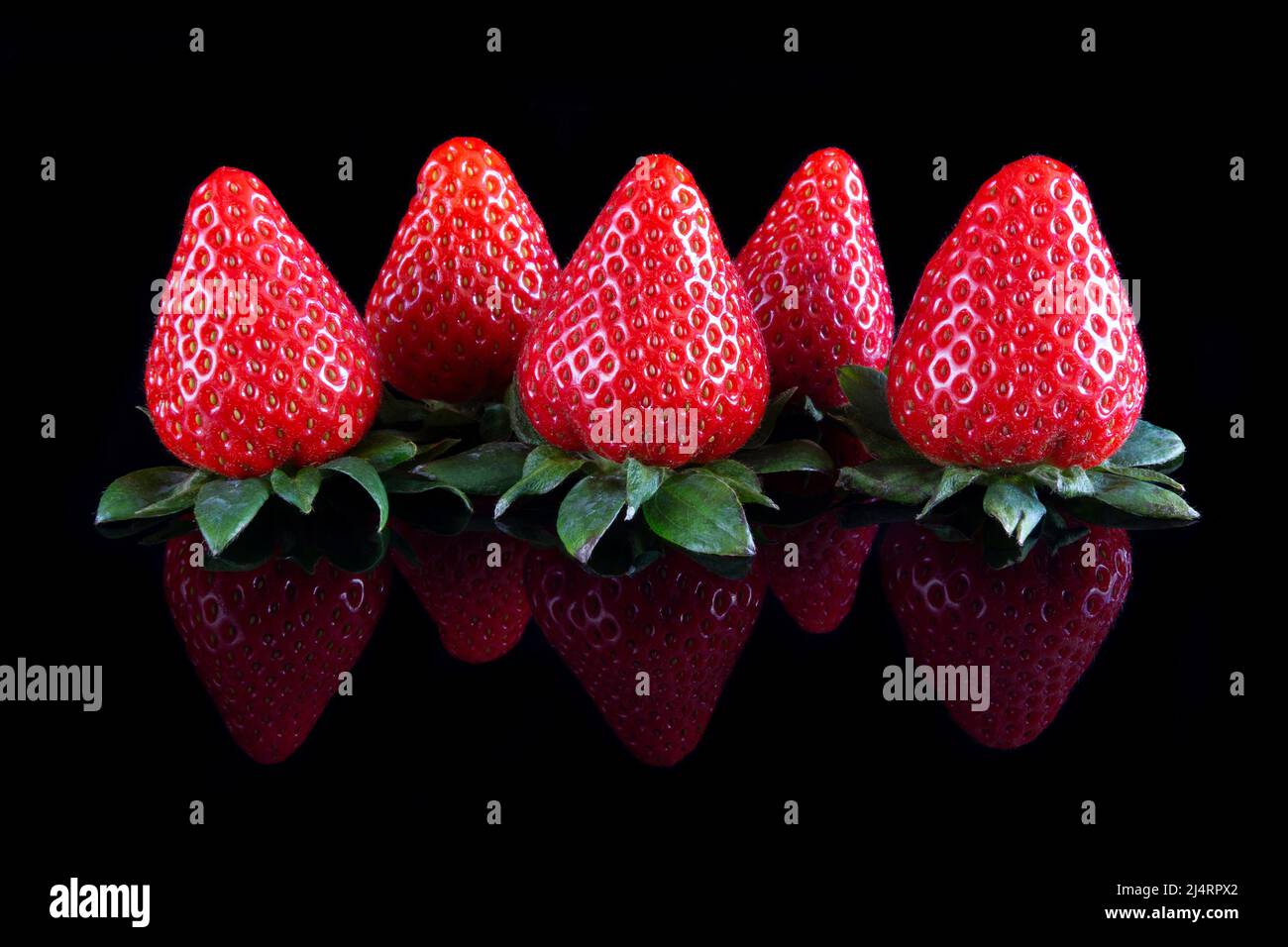 Fresh strawberries over reflective black background Stock Photo - Alamy