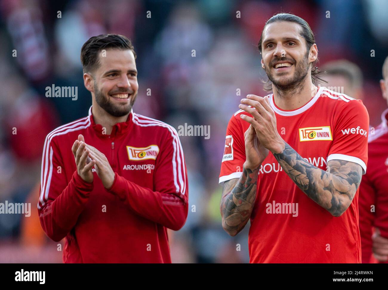 Berlin, Germany. 17th Apr, 2022. Soccer: Bundesliga, 1. FC Union Berlin - Eintracht Frankfurt, Matchday 30, An der Alten Försterei. Berlin's Niko Gießelmann (l) and Christopher Trimmel laugh and thank the crowd after the win. Credit: Andreas Gora/dpa - IMPORTANT NOTE: In accordance with the requirements of the DFL Deutsche Fußball Liga and the DFB Deutscher Fußball-Bund, it is prohibited to use or have used photographs taken in the stadium and/or of the match in the form of sequence pictures and/or video-like photo series./dpa/Alamy Live News Stock Photo