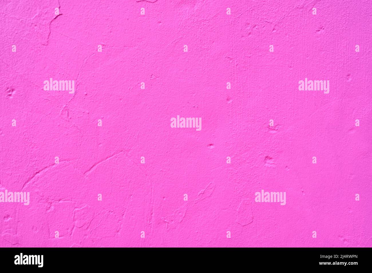 detail of an irregular stucco wall painted pink or fusia Stock Photo