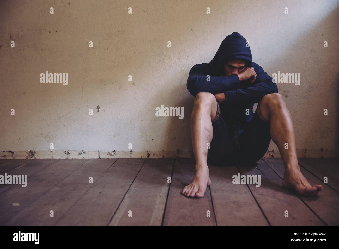 sad man sitting alone in the dark Stock Photo - Alamy