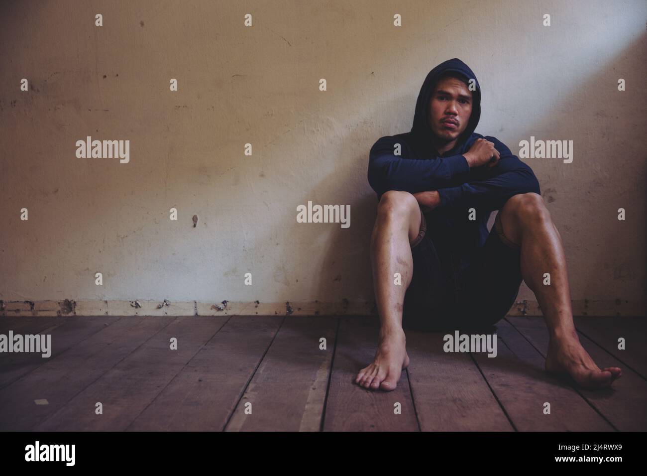 sad man sitting alone in the dark Stock Photo - Alamy