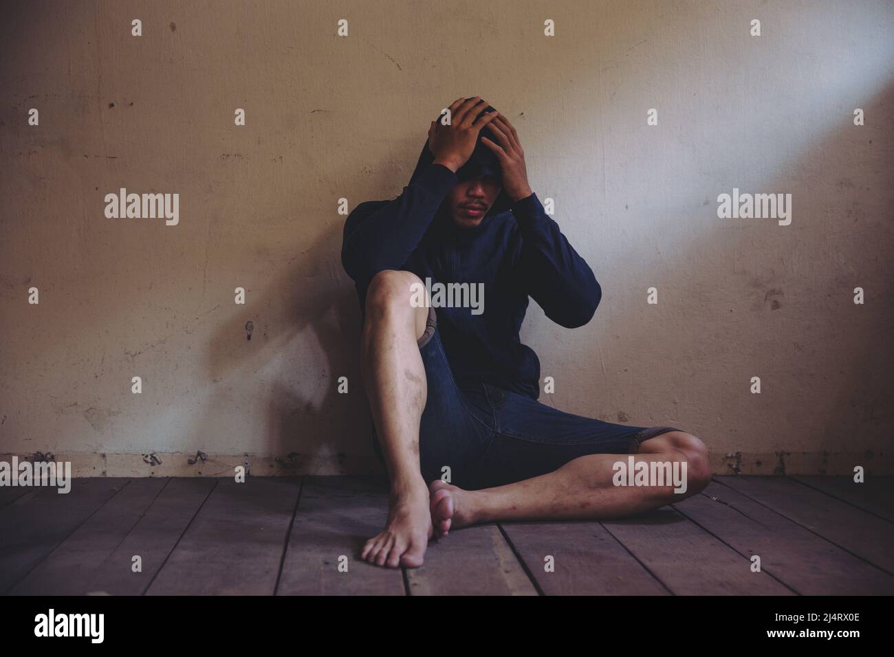 sad man sitting alone in the dark Stock Photo - Alamy