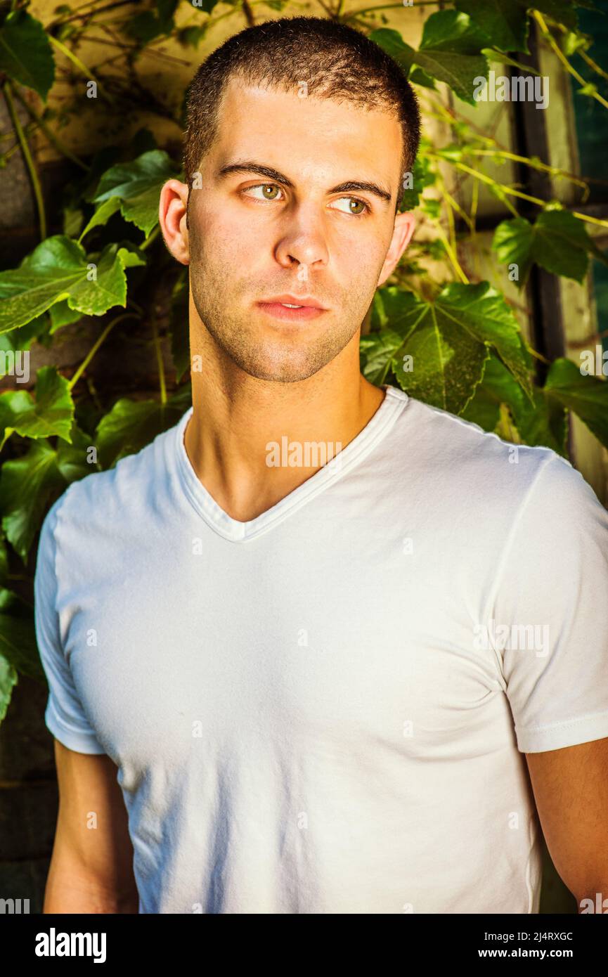 Portrait of young man, wearing a white V neck T shirt,  short hair. Stock Photo