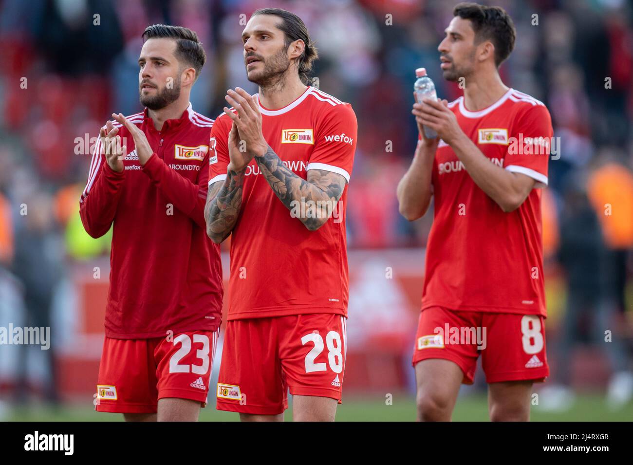 Berlin, Germany. 17th Apr, 2022. Soccer: Bundesliga, 1. FC Union Berlin - Eintracht Frankfurt, Matchday 30, An der Alten Försterei. Berlin's Niko Gießelmann (l-r), Christopher Trimmel and Rani Khedira laugh and thank the crowd after the win. Credit: Andreas Gora/dpa - IMPORTANT NOTE: In accordance with the requirements of the DFL Deutsche Fußball Liga and the DFB Deutscher Fußball-Bund, it is prohibited to use or have used photographs taken in the stadium and/or of the match in the form of sequence pictures and/or video-like photo series./dpa/Alamy Live News Stock Photo