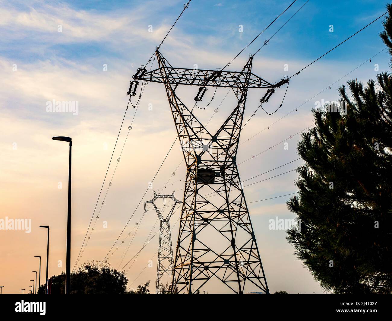 Large electricity distribution towers at sunset Stock Photo