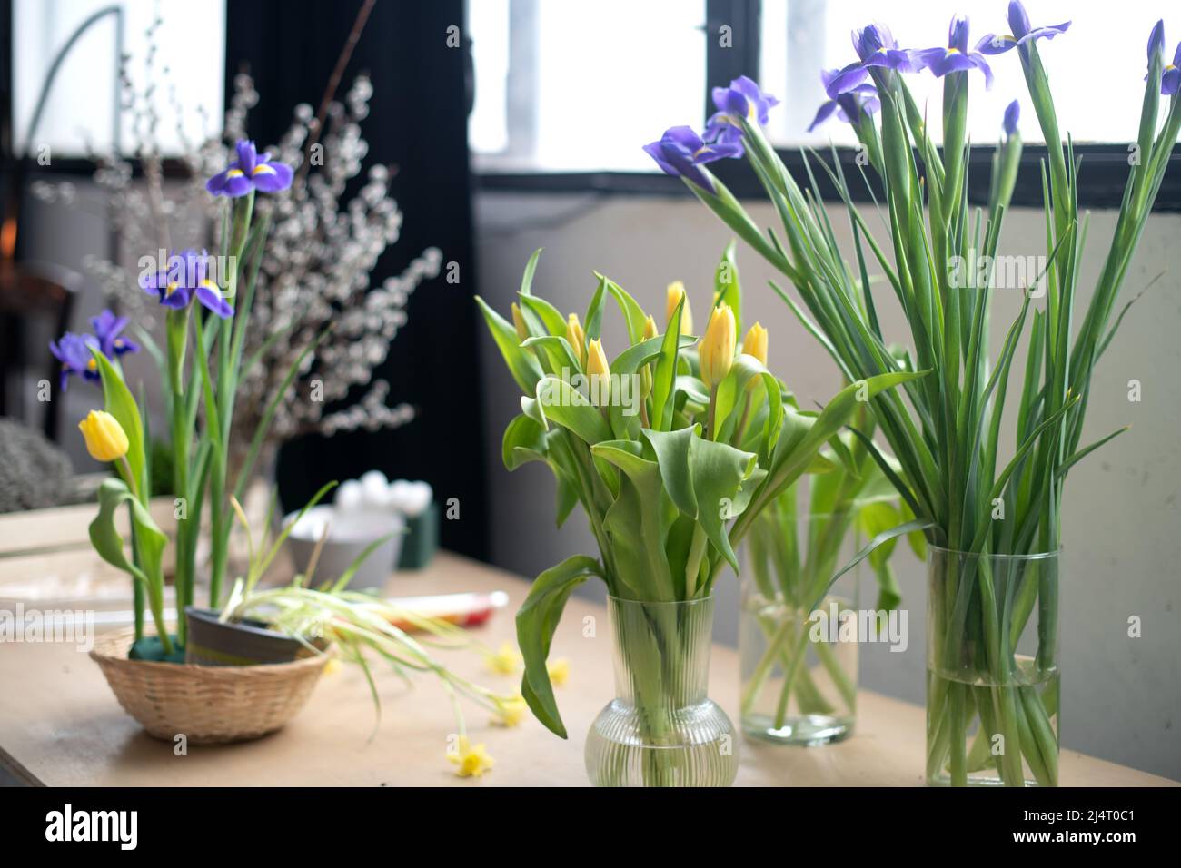 Spring Easter bouquets of fresh flowers in vases on the table at home. Stock Photo