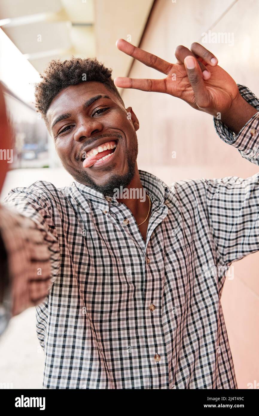 africanamerican man taking a selfie with funny face sticking out his