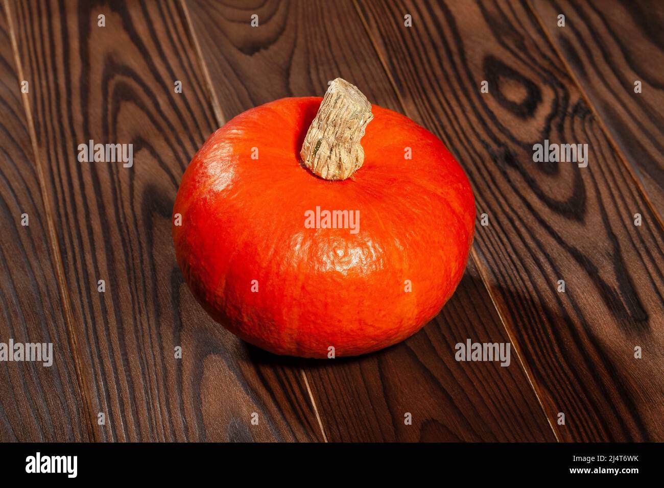 red kuri squash on brown wood background Stock Photo - Alamy