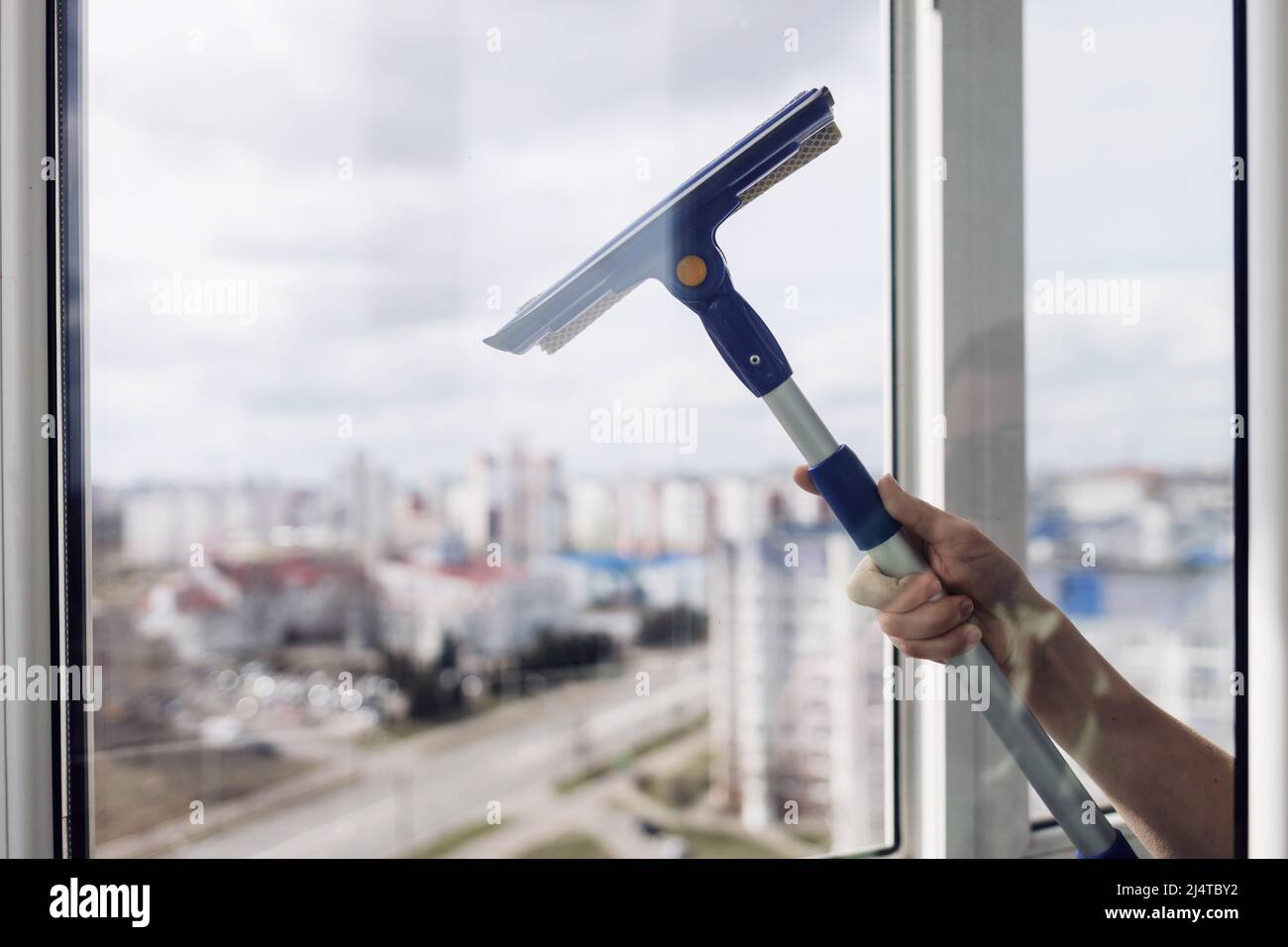 Washing and cleaning the window with a squeegee. cleaning services Stock Photo Alamy