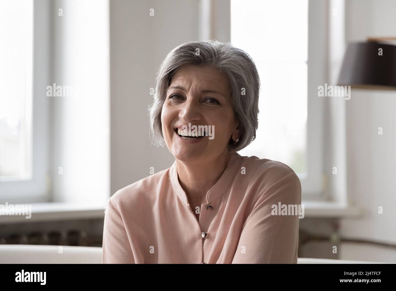 Headshot portrait attractive older woman smile look at camera Stock Photo