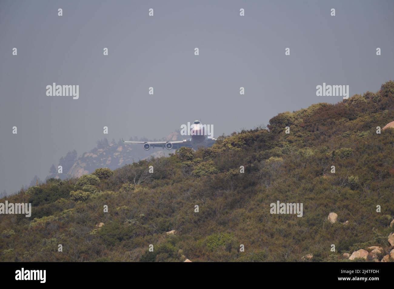Global Super Tanker approaches over a hill for a Phoscheck drop, at the Valley Fire in  San Diego county, California Stock Photo