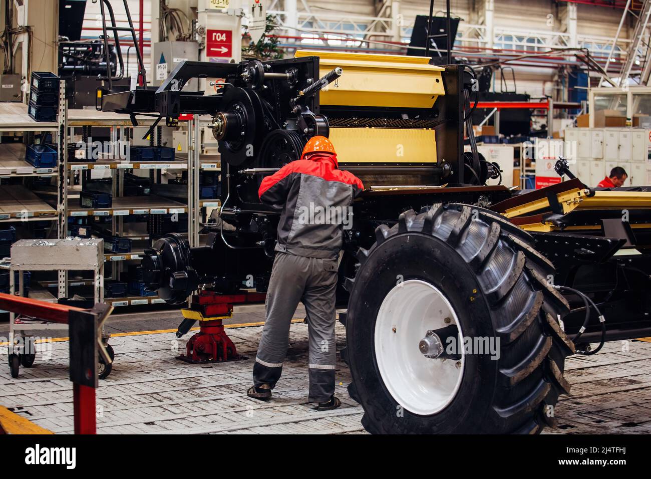 Industrial workers assembles agricultural harvester in workshop. Stock Photo