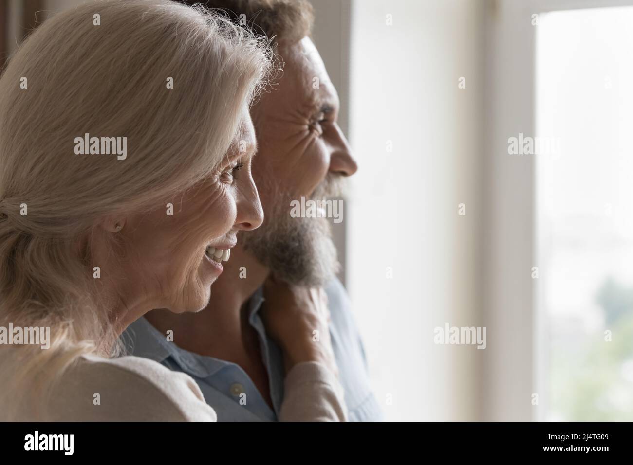 Closeup side profile faces of older spouses staring into distance Stock Photo