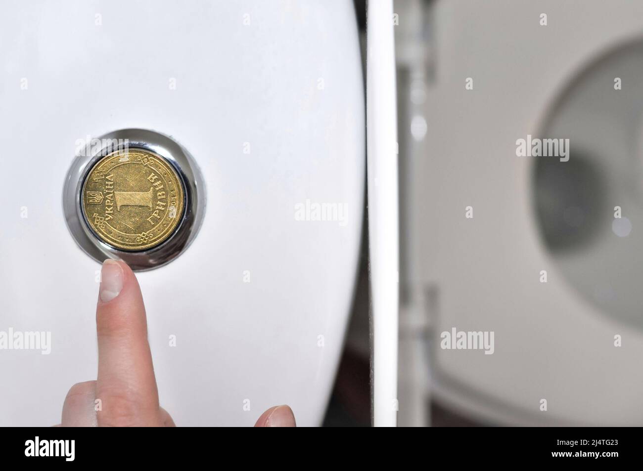 faucets in the bathroom with a Ukrainian hryvnia coin, translation from Ukrainian: one hryvnia, ukraine.  Stock Photo