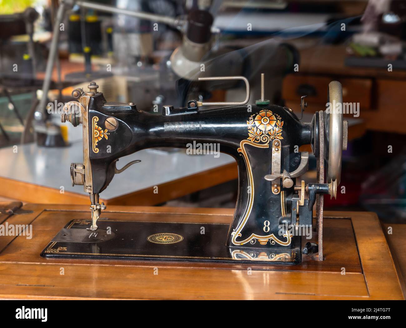 Annecy, France - January 7, 2022: A retro sewing machine with beautiful ornaments in an antique shop window in Annecy Stock Photo