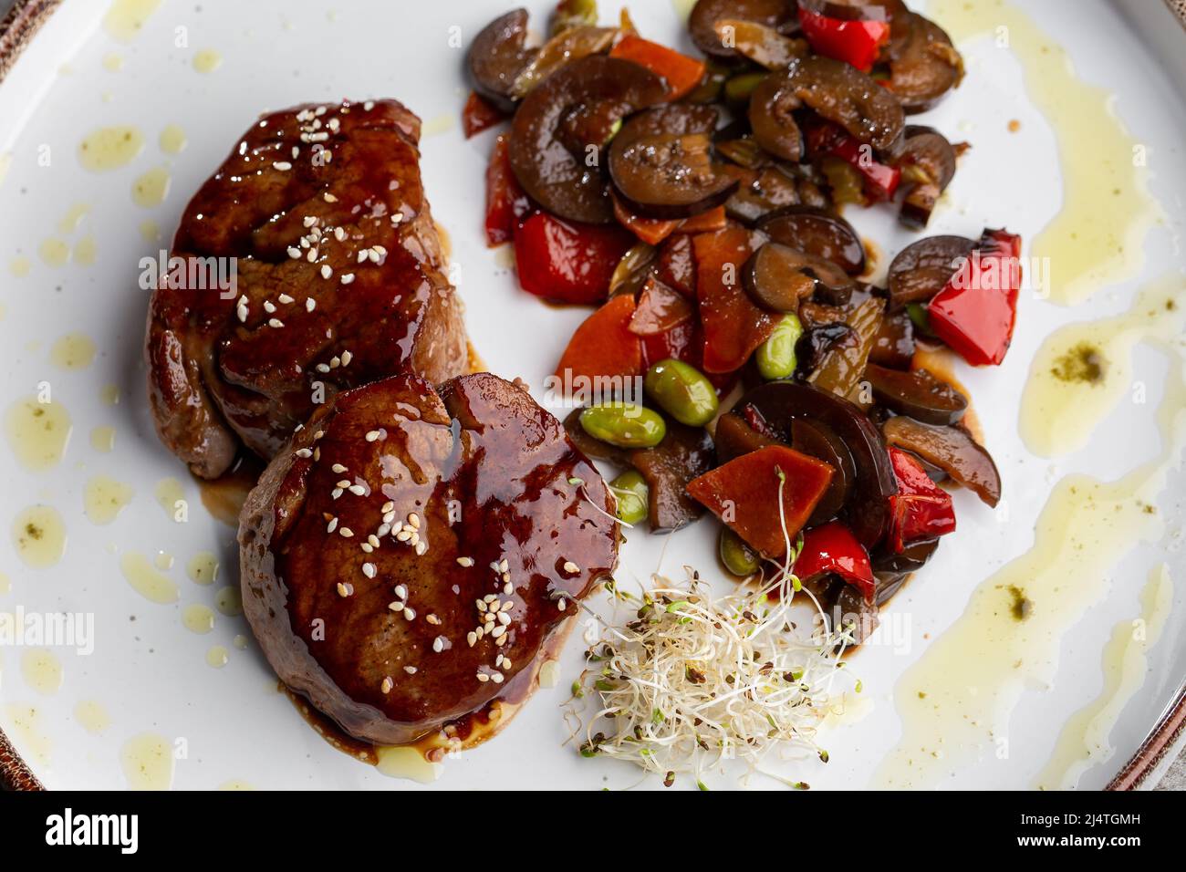 Grilled meat fillet steak wrapped in bacon medallions with raspberry