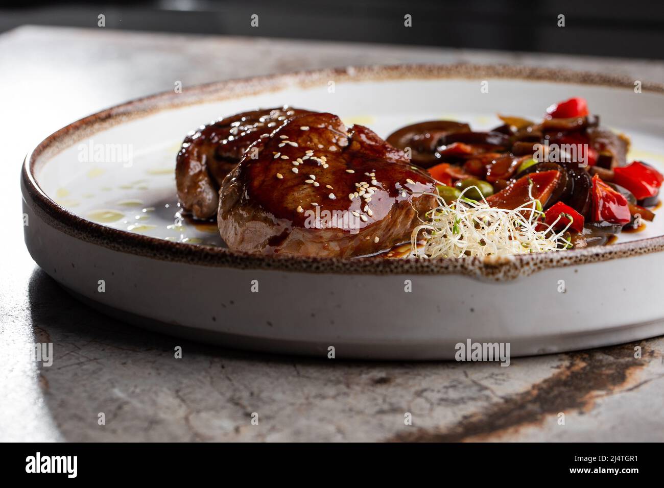 Grilled meat fillet steak wrapped in bacon medallions with raspberry