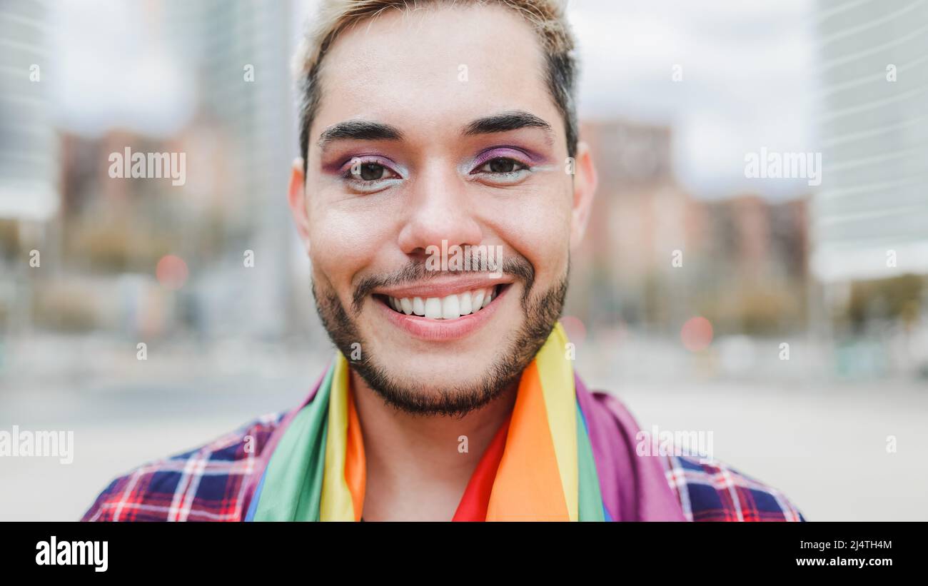 Gay man with makeup on wearing rainbow flag outdoor - LGBTQ drag queen concept Stock Photo