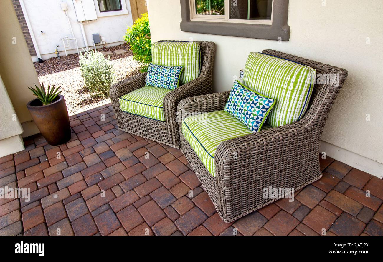 Two Wicker Arm Chairs With Cushions On Pavers Front Patio Stock Photo ...
