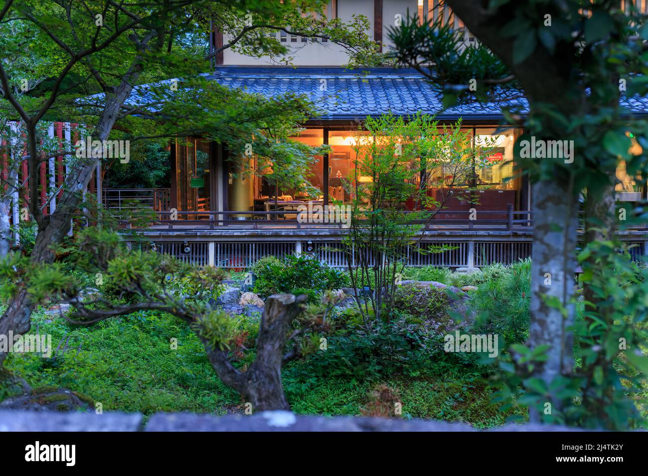 Japanese garden around lit restaurant at dusk Stock Photo Alamy