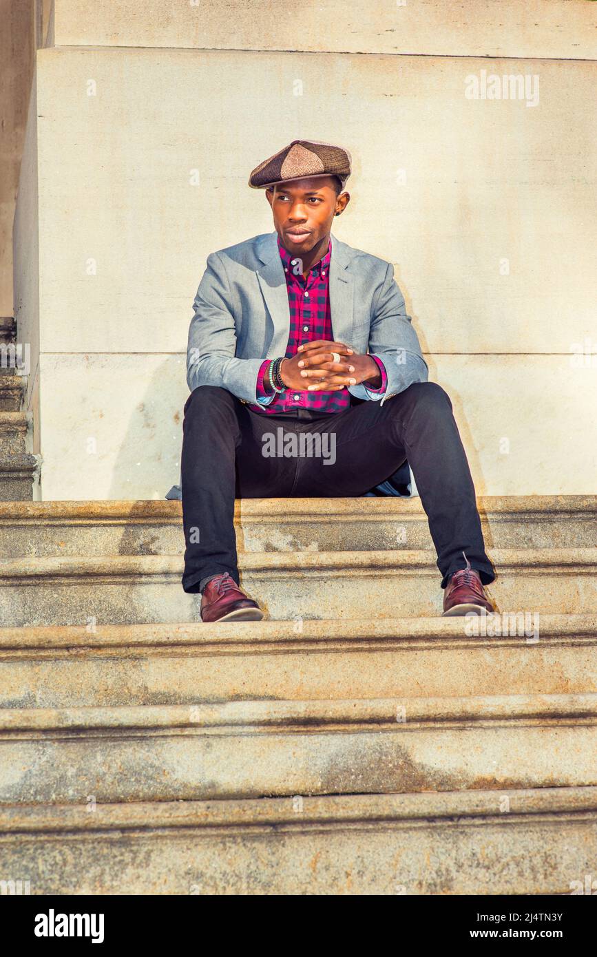 Man Urban Fashion. Wearing a Apple Newsboy cap, dressing in light gray blazer, patterned pink, black under shirt, black pants, brown leather shoes, a Stock Photo