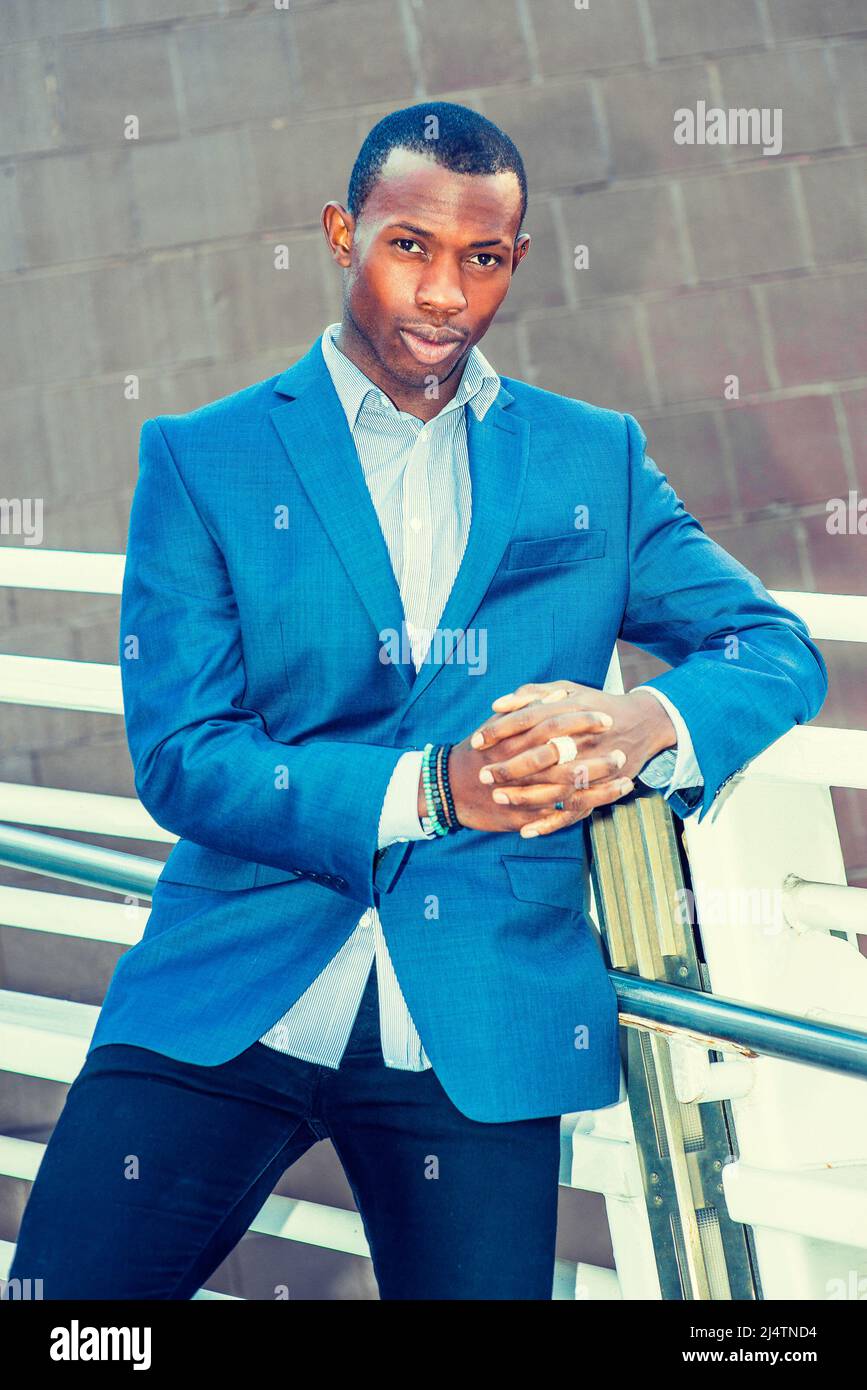 Portrait of Young Business Man. Wearing a blue blazer, black pants,, short  haircut, bracelets, finger ring, a young black guy is standing against meta  Stock Photo - Alamy