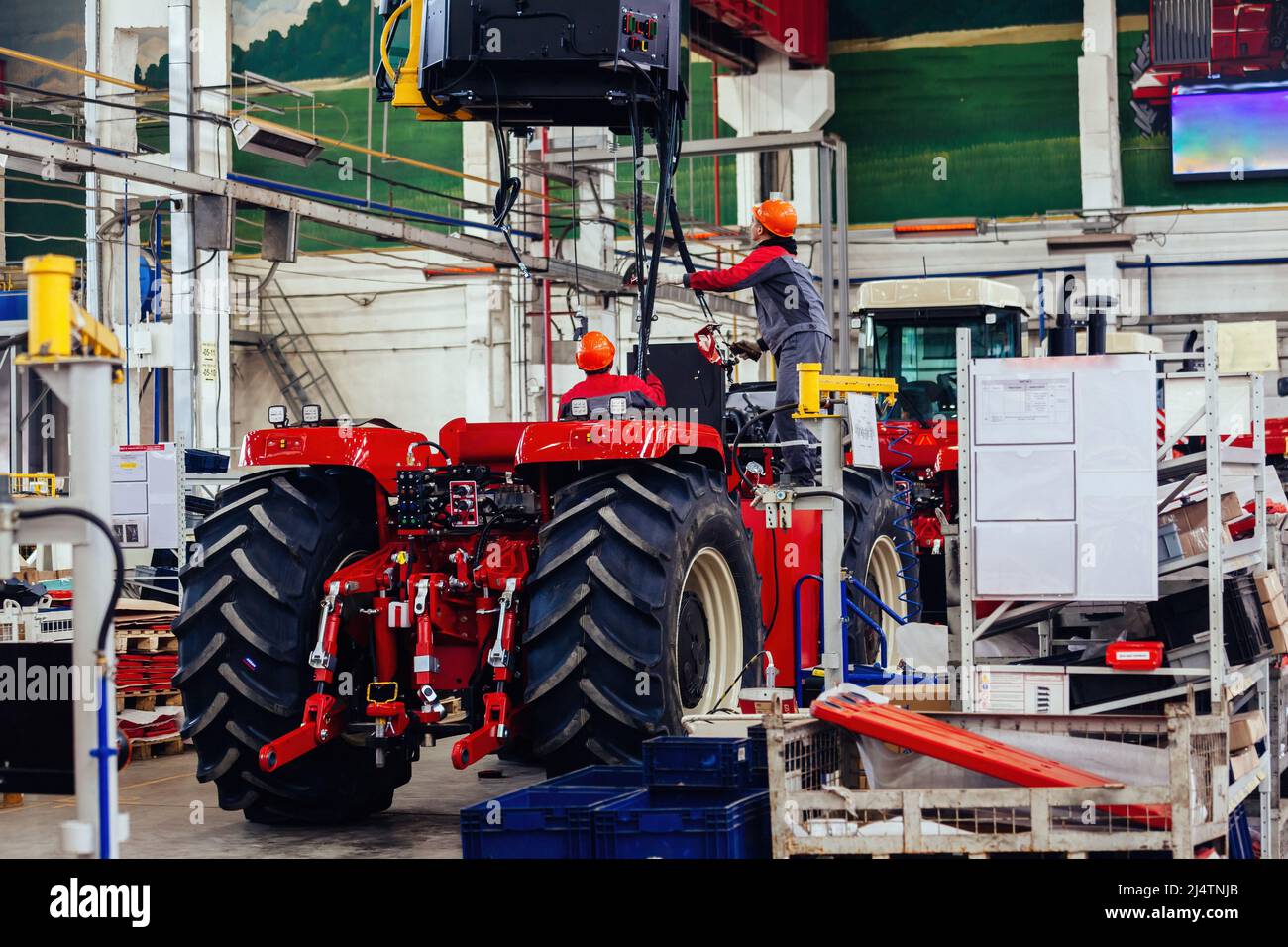 Industrial Workers Assembles Agricultural Tractor In Workshop Stock