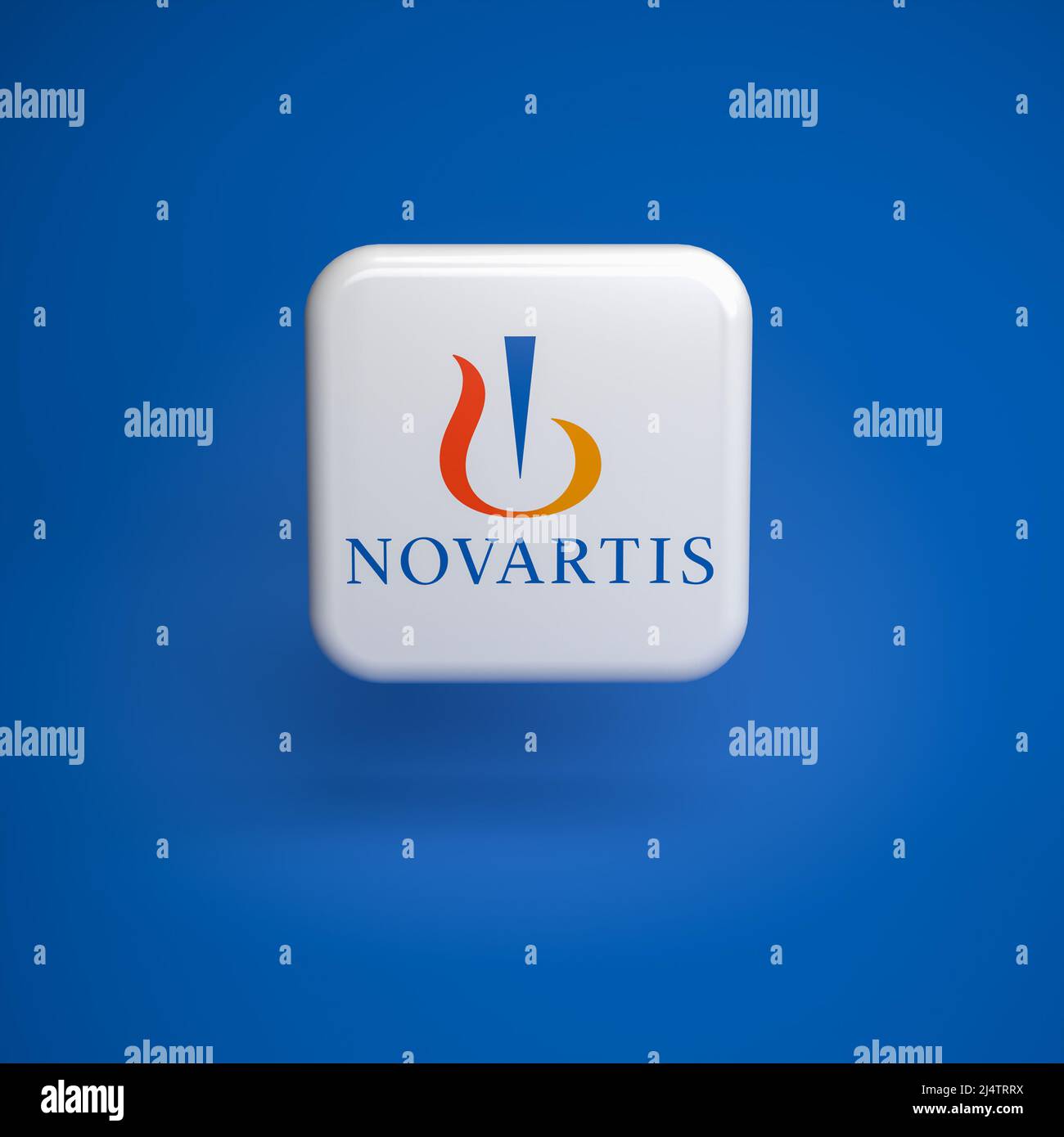 Logo of the Swiss pharmaceutical company Novartis hovering over a seamless blue background Stock Photo