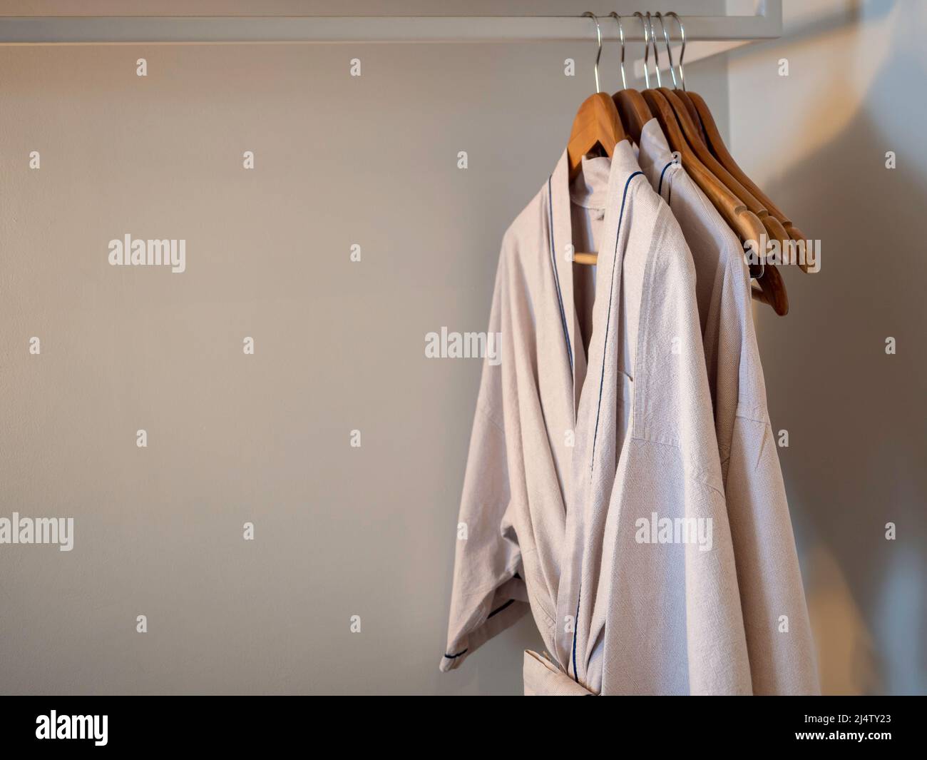 Couple of Japanese style cotton bathrobes hanging on the wooden hangers