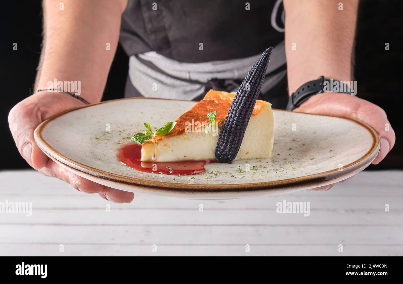 Chef presenting plate of New York cheesecake or classic cheesecake with fresh, appetizing healthy. Stock Photo