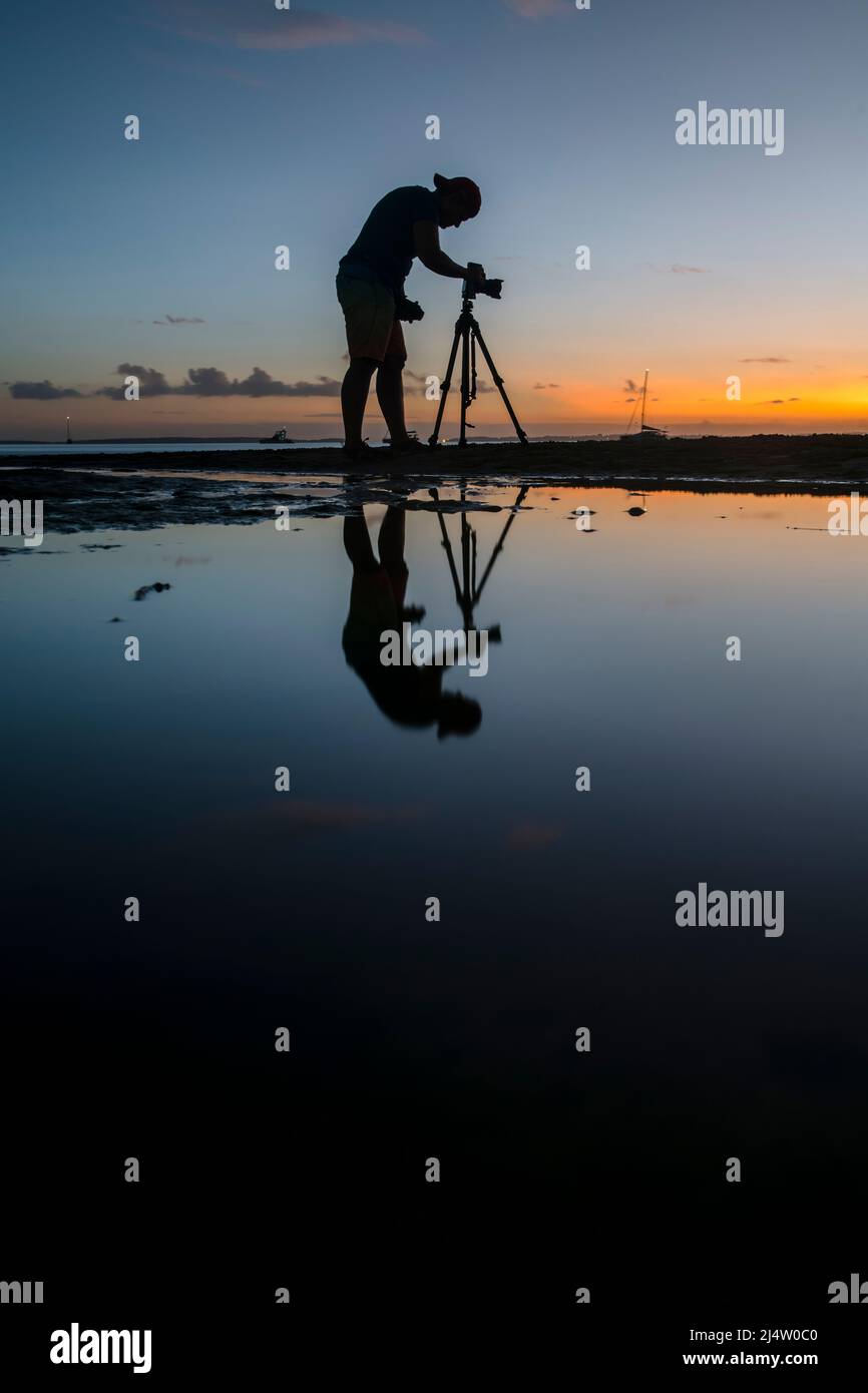 A photographer taking photos at sunset at Kingfisher Bay on Fraser Island, Queensland, Australia. Stock Photo