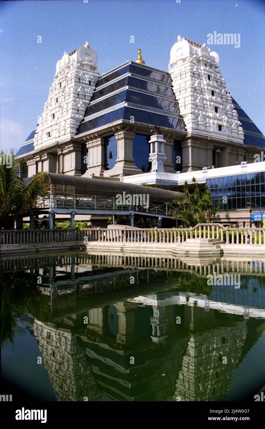 View of modern tower of ISKCON Temple and its reflection in pond water below, Bengaluru, Karnataka, India, Asia Stock Photo