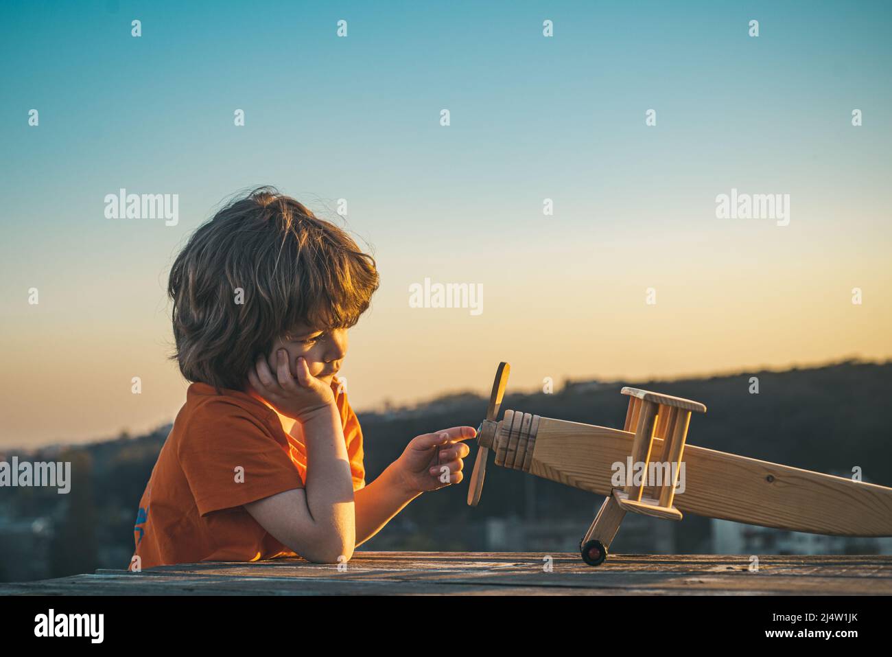 Happy kid playing with toy airplane against blue sky background. Cute ...