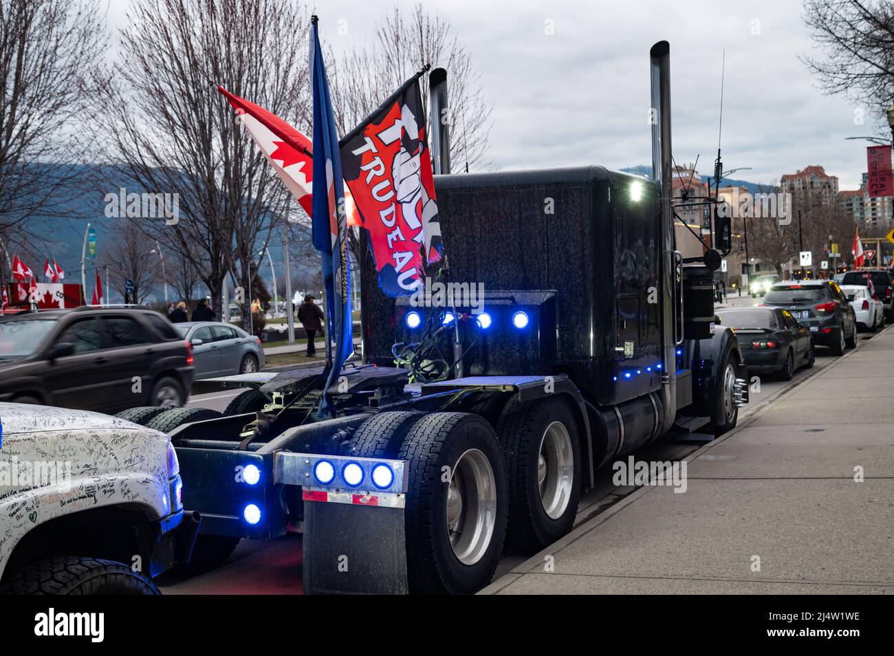 A blue semi with Canadian and anti-Trudeau flags parked on the street as part of an event to protest the country's vaccine and COVID restrictions. Stock Photo