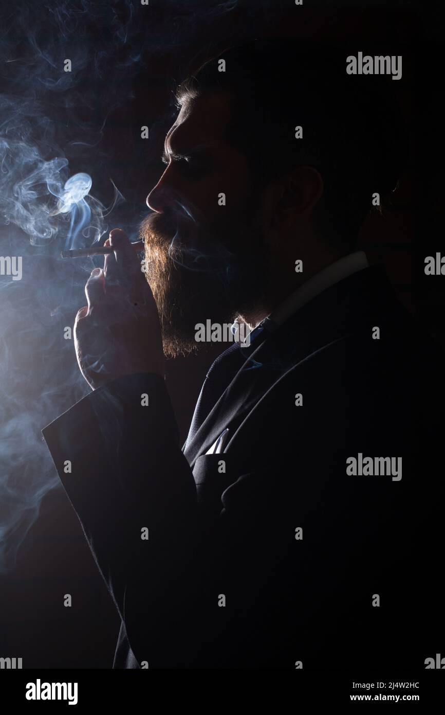 Smoke on black. Man smoking cigarette. Smoker businessman. Stock Photo