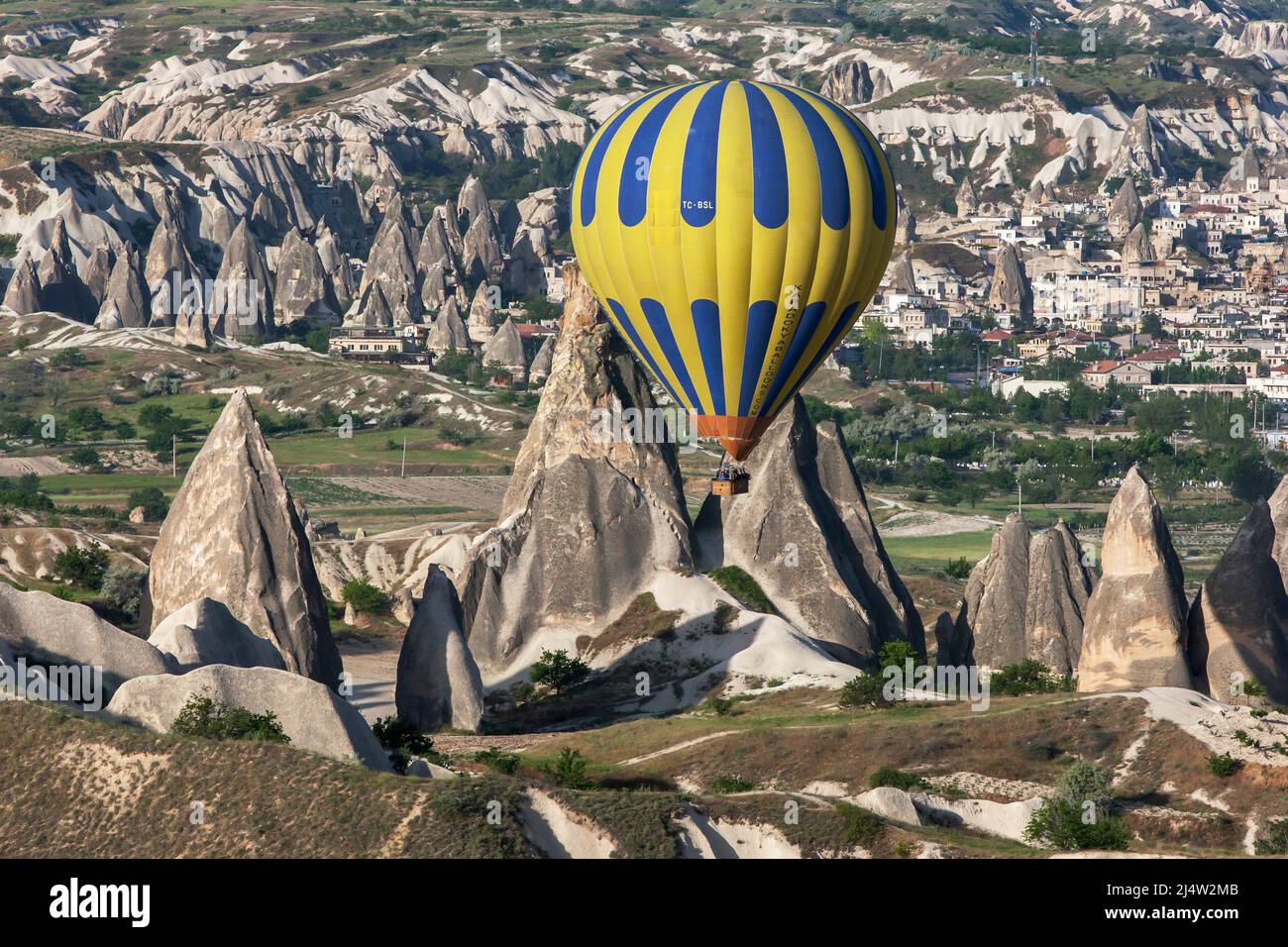 A hot air balloon floats past volcanic rock formations known as fairy  chimneys at Goreme in the Cappadocia region of Turkey Stock Photo - Alamy