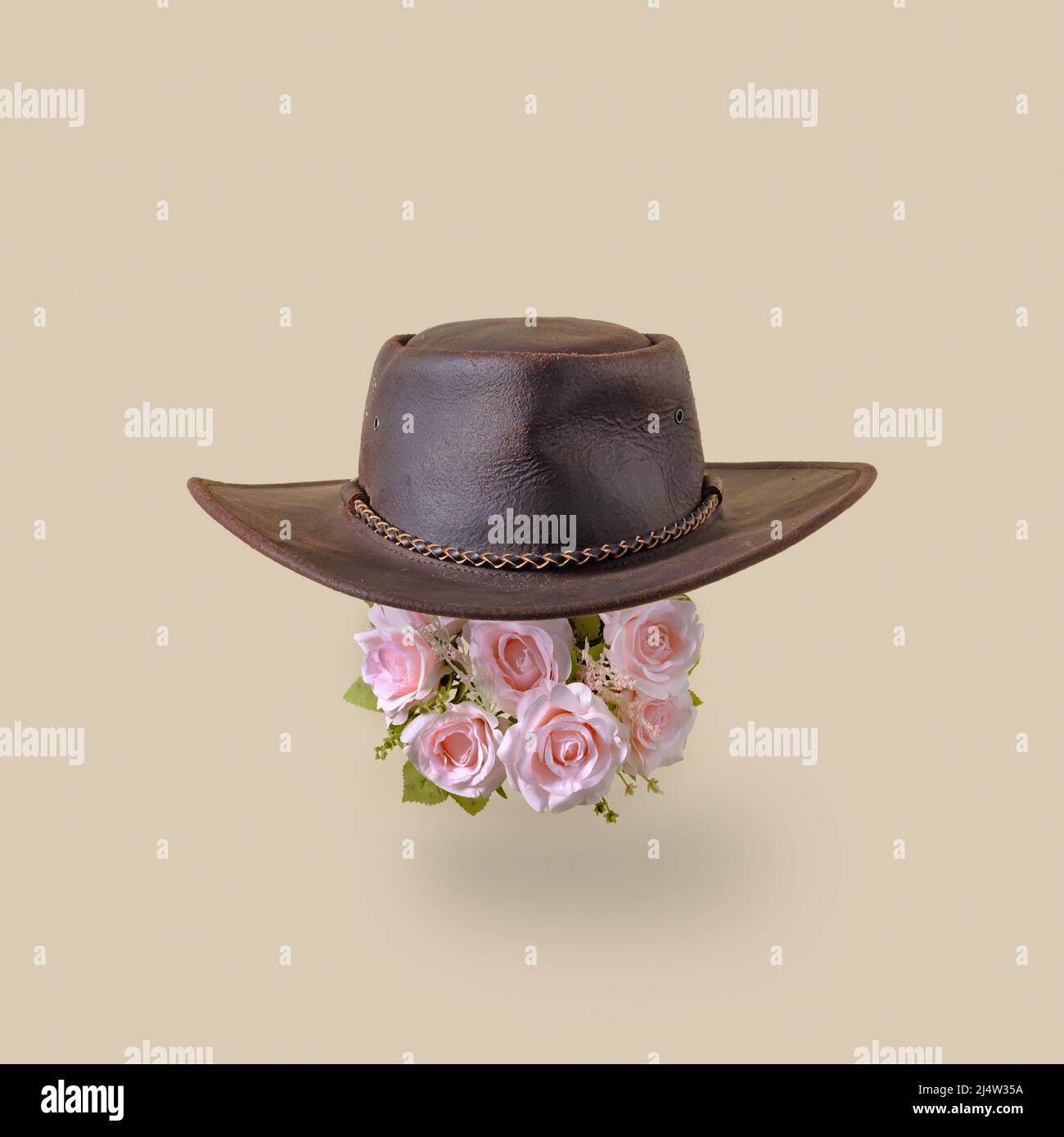 Leather retro vintage america cowboy hat and pink rose flowers. Minimal trend wild west concept. Stock Photo