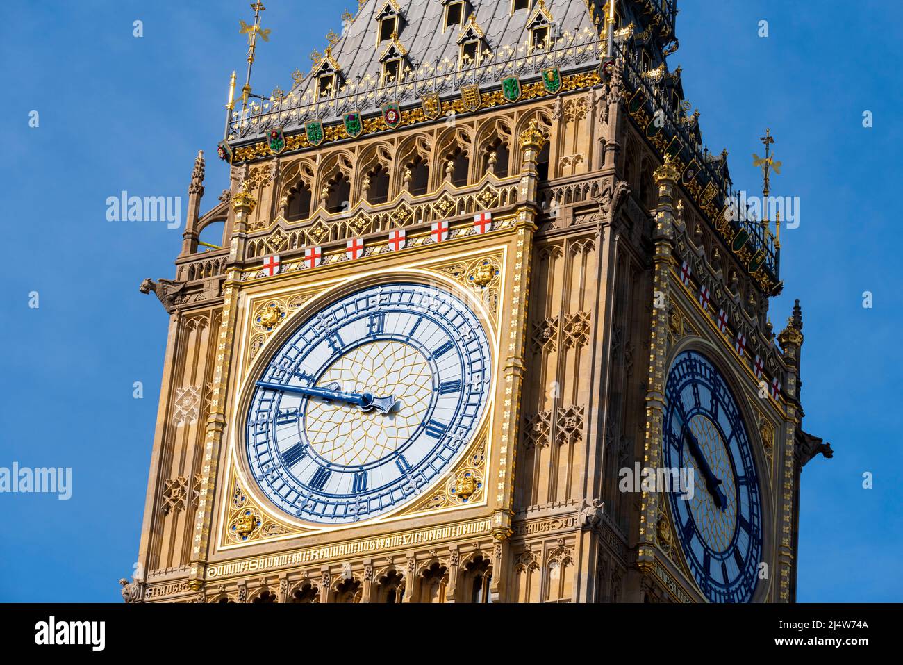 Upper detail of recently uncovered restored Elizabeth Tower, Big Ben, of the Palace of Westminster, London. Bright colours. Clock face with blue hands Stock Photo