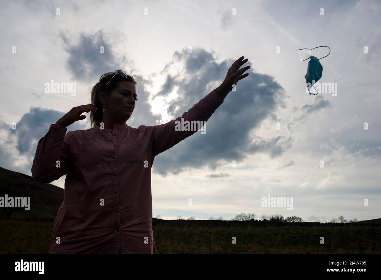 A model poses releasing a face mask as the restrictions requiring mask